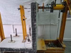 Laboratory rig testing a wall specimen under load.